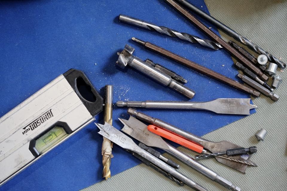 Hand tools and a spirit level laid out on a blue work surface